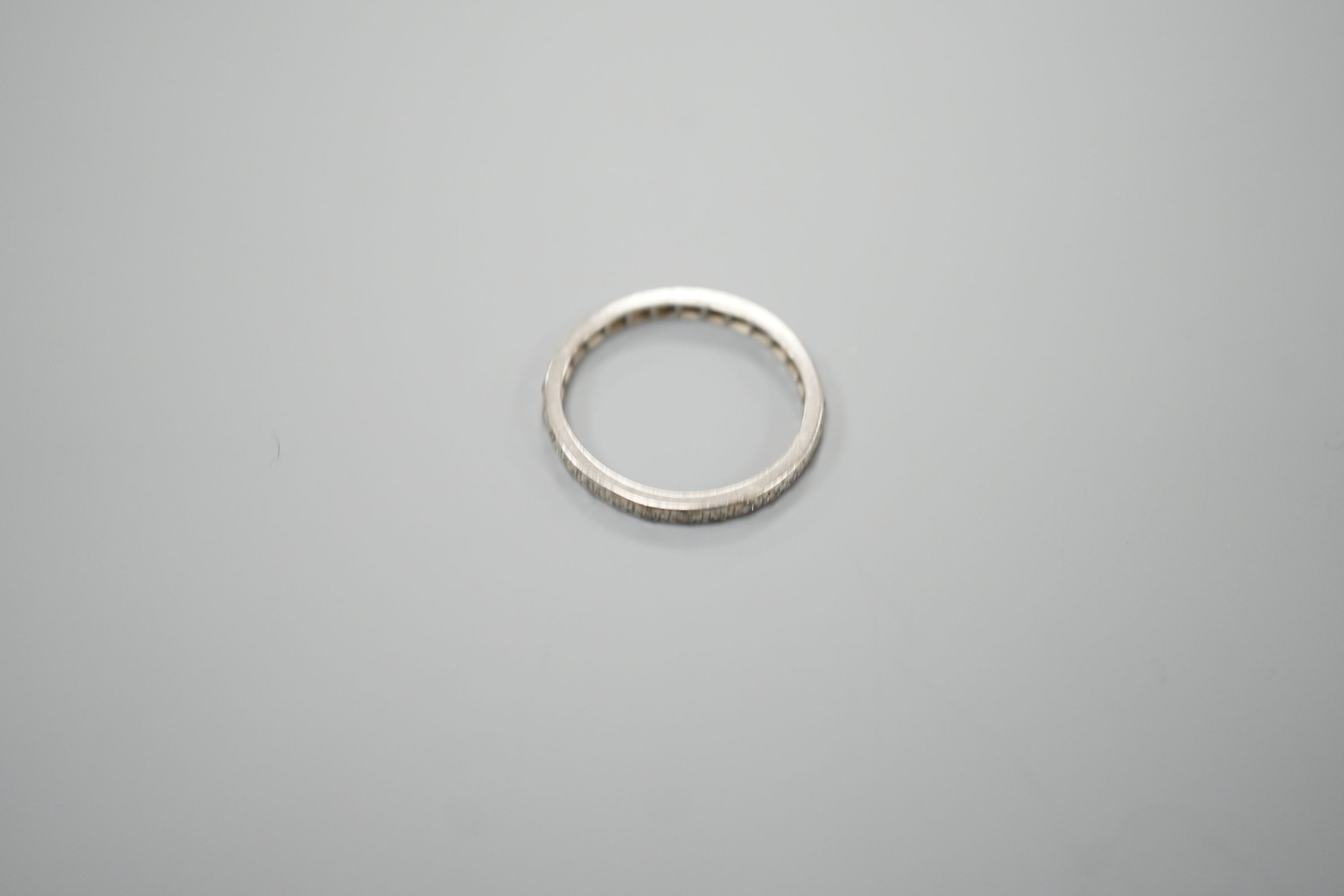 A white metal and diamond chip set full eternity ring, size O/P, gross weight 2.4 grams.